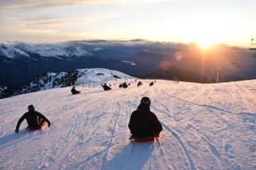 Descente en luge au coucher du soleil et de nuit